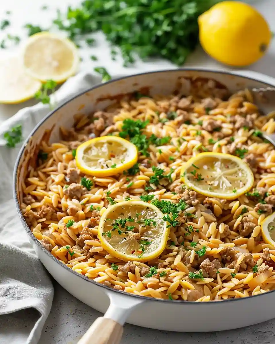 A white bowl filled with creamy One-Pot Lemon Turkey Orzo garnished with feta and parsley.
